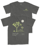 a gray t-shirt with a graphic design depicting a tree and a moon. The t-shirt has text on the back that reads "JOSUA TREE 33.734 N. CA. 1019 W."