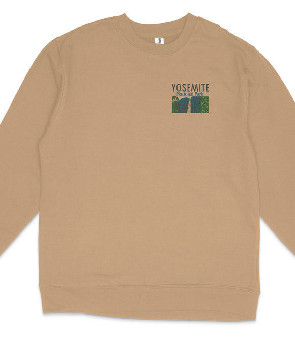 A beige long-sleeved shirt with a graphic design on the front, featuring the text "YOSEMITE NATIONAL PARK" and an image of a mountain range.