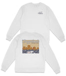 A white long-sleeved shirt with a graphic design depicting a scenic landscape, including mountains and a body of water.