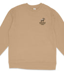 A tan long-sleeved shirt with a small logo on the left side depicting a mountain goat.