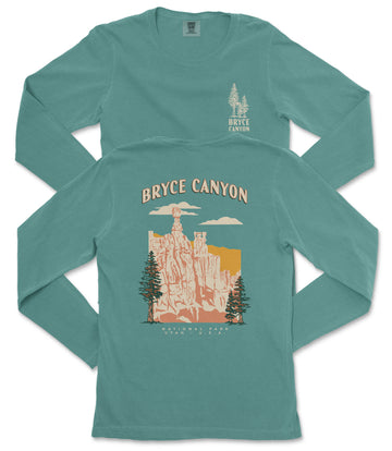 A long-sleeved teal-colored t-shirt with a graphic design depicting Bryce Canyon National Park, featuring a mountain landscape with a prominent rock formation and a sunset.