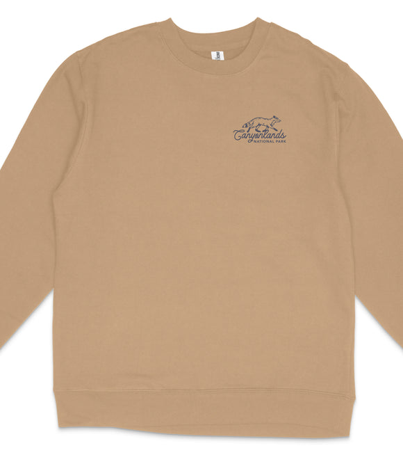 A tan long-sleeved shirt with a blue logo on the left side.