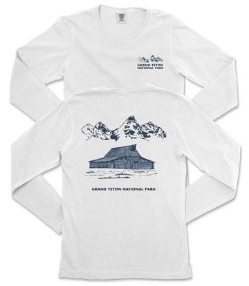 A white long-sleeved t-shirt with a graphic design depicting a cabin and mountains, along with text that reads "Grand Teton National Park".