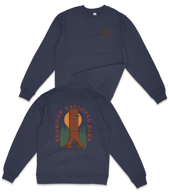 a navy blue sweatshirt with a graphic design on the back, depicting a tall tree with a sun-like symbol above it, surrounded by green trees.