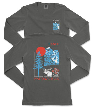 a gray long-sleeved t-shirt with a graphic design depicting a mountain range and a sun. The design includes a tree, a mountain, and a red circle with a sun-like shape. The text on the t-shirt reads "BANFF NATIONAL PARK".