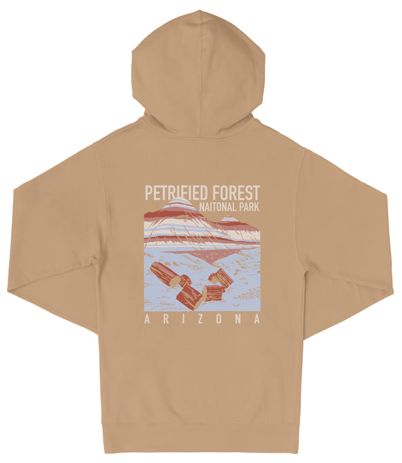A beige hooded sweatshirt with a graphic design depicting a scenic landscape, including a mountain range and a body of water. The text on the back of the sweatshirt reads "PETRIFIED FOREST NATIONAL PARK ARIZONA".