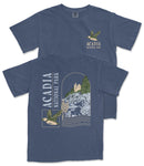 A blue t-shirt with a graphic design depicting a bird flying over a mountainous landscape, along with text that reads "ACADIA NATIONAL PARK".