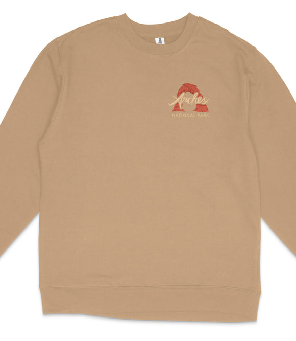 A beige long-sleeved shirt with a red graphic and text on the left side.