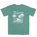 a green t - shirt with a picture of a wave and palm trees