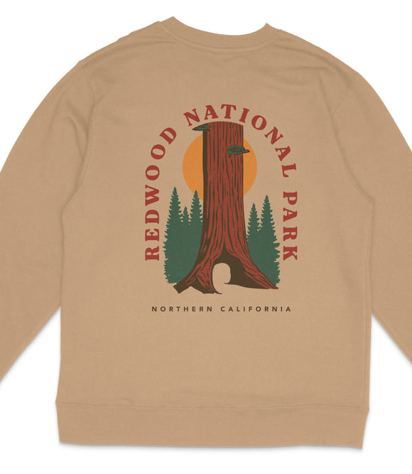 A beige sweatshirt with a graphic design featuring a tall tree and the text "REDWOOD NATIONAL PARK NORTHERN CALIFORNIA".