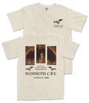 a cream-colored t-shirt with a graphic design depicting a cave scene, including a bat flying above the cave entrance. The text on the t-shirt reads "MAMMOTH CAVE NATIONAL PARK" and "KENTUCKY 37.846 mi 2.844 Hr ESTABLISHED 1941".
