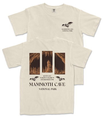 a cream-colored t-shirt with a graphic design depicting a cave scene, including a bat flying above the cave entrance. The text on the t-shirt reads "MAMMOTH CAVE NATIONAL PARK" and "KENTUCKY 37.846 mi 2.844 Hr ESTABLISHED 1941".