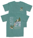 A green t-shirt with a graphic design depicting a bird and a landscape with a building, along with text that says "ACADIA NATIONAL PARK".