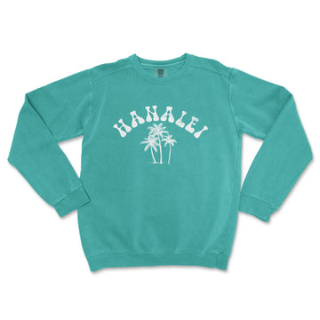 a green sweatshirt with a palm tree and the word hawaii printed on it
