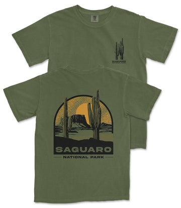 A green t-shirt with a graphic design depicting a desert landscape with cacti and mountains, along with the text "Saguaro National Park".