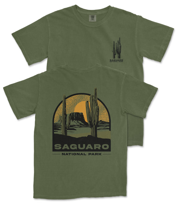 A green t-shirt with a graphic design depicting a desert landscape with cacti and mountains, along with the text "Saguaro National Park".