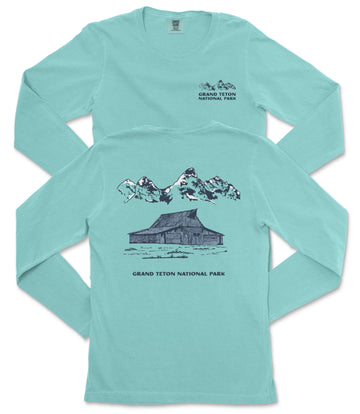 A turquoise long-sleeved t-shirt with a graphic design depicting a cabin and mountains, along with text that reads "Grand Teton National Park".