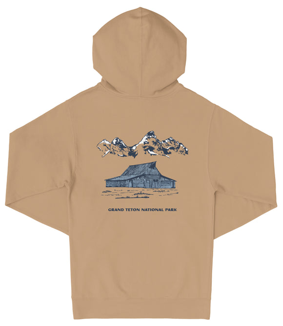 A tan hooded sweatshirt with a graphic design depicting a cabin and mountains in the background, along with the text "Grand Teton National Park".