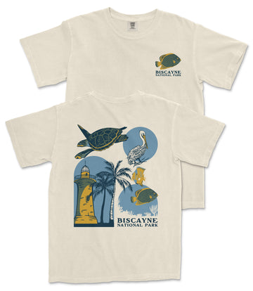 A white t-shirt with a graphic design depicting various elements associated with Biscayne National Park, including a lighthouse, palm trees, and marine life.