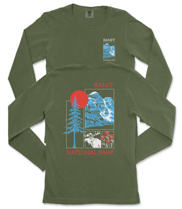 a green long-sleeved t-shirt with a graphic design featuring a mountain range, a tree, and a red sun. The text on the t-shirt reads "BANFF NATIONAL PARK".