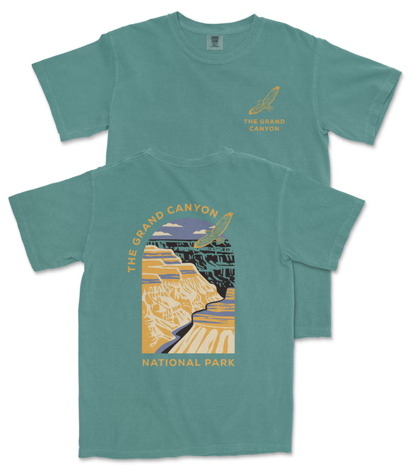 A green t-shirt with a graphic design depicting the Grand Canyon, along with the text "The Grand Canyon National Park".