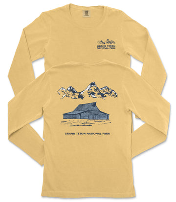 A yellow long-sleeved t-shirt with a graphic design depicting a cabin and mountains, along with text that reads "Grand Teton National Park".