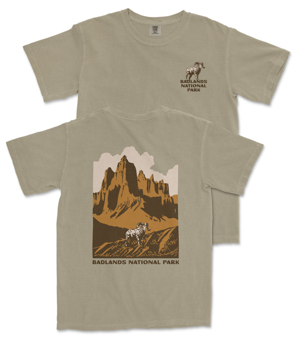 a t-shirt with a graphic design depicting a mountain landscape with a goat in the foreground.