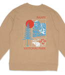 A beige sweatshirt with a graphic design featuring a red sun, blue mountains, and various wildlife elements such as a moose and flowers.