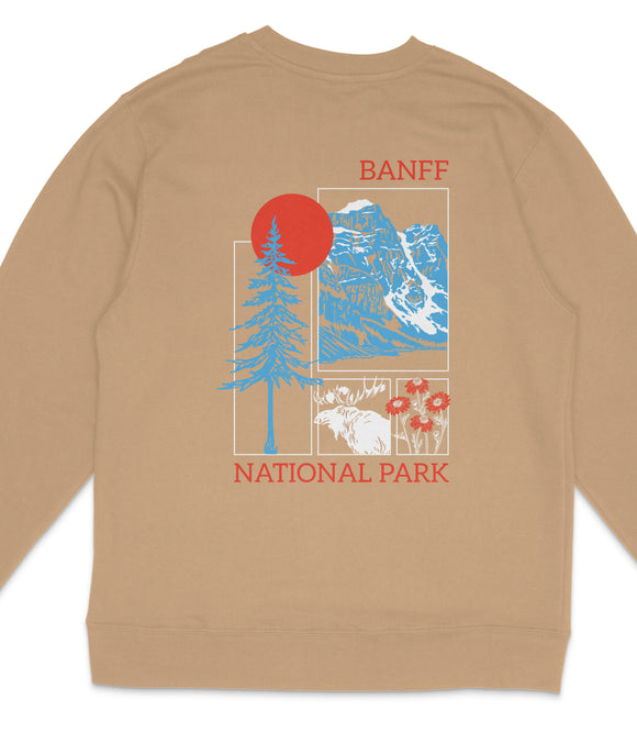 A beige sweatshirt with a graphic design featuring a red sun, blue mountains, and various wildlife elements such as a moose and flowers.