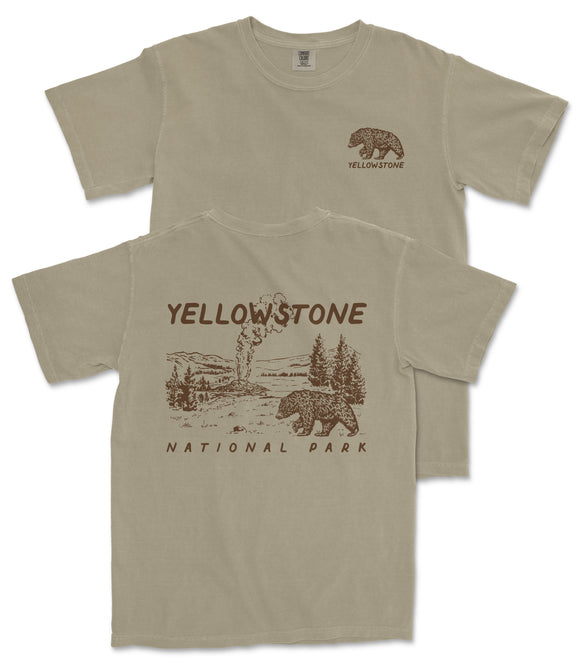 A beige t-shirt with a graphic design depicting a bear and a landscape, along with the text "Yellowstone National Park" printed on it.