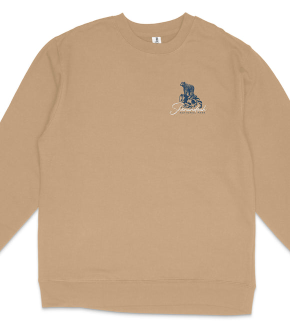 A tan long-sleeved shirt with a blue and white graphic design on the front.