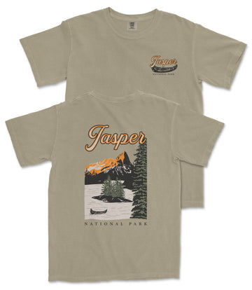 a beige t-shirt with a graphic design depicting a scenic landscape with mountains, a lake, and a canoe. The text on the t-shirt reads "Jasper National Park" and "National Park".
