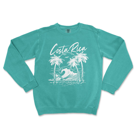 a turquoise sweatshirt with a palm tree and a surfboard on it