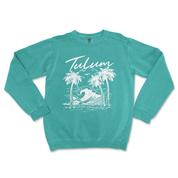 a turquoise sweatshirt with a palm tree and a wave in the ocean