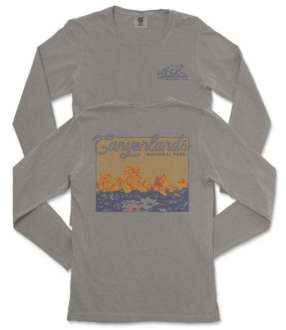 a gray long-sleeved t-shirt with a graphic design depicting a scenic landscape, including mountains and a body of water.