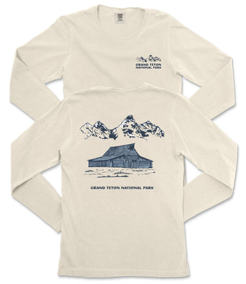 a cream-colored long-sleeved t-shirt with a graphic design depicting a cabin and mountains, along with the text "Grand Teton National Park" printed on the back.