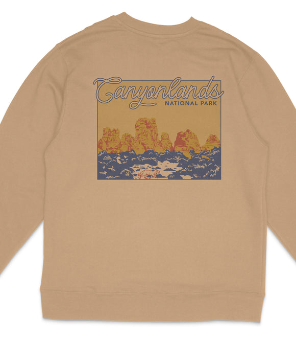 a beige sweatshirt with a graphic design depicting a scenic landscape with mountains and a body of water.