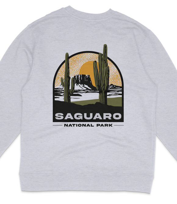 A gray sweatshirt with a graphic design depicting a desert landscape with two cacti and a sun in the background, along with the text "Saguaro National Park".