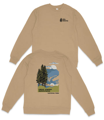 a beige sweatshirt with a graphic design depicting a mountain landscape with pine trees and a cloudy sky.