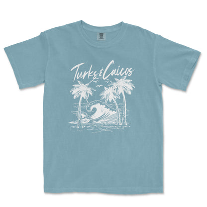 a blue t - shirt with a picture of a wave and palm trees
