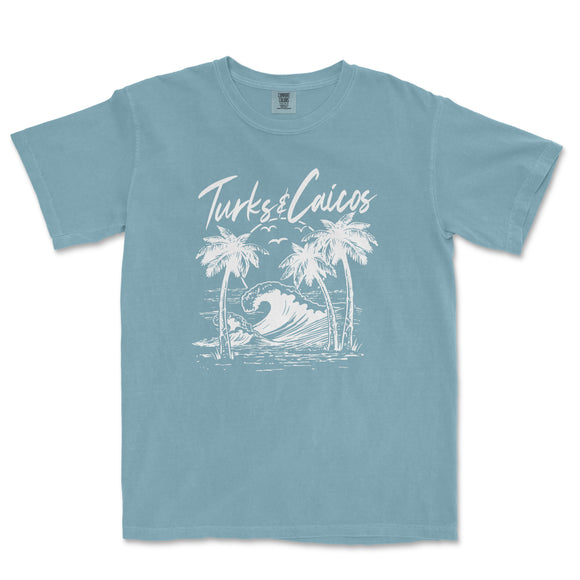 a blue t - shirt with a picture of a wave and palm trees