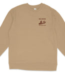 A tan long-sleeved shirt with a graphic design on the left side, depicting a person in a canoe and the text "BIG BEND NATIONAL PARK".