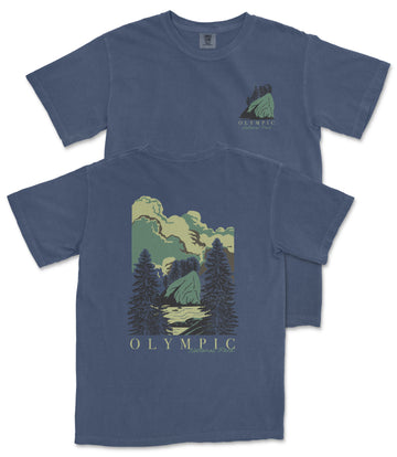 A blue t-shirt with a graphic design depicting a mountain landscape with pine trees and clouds.
