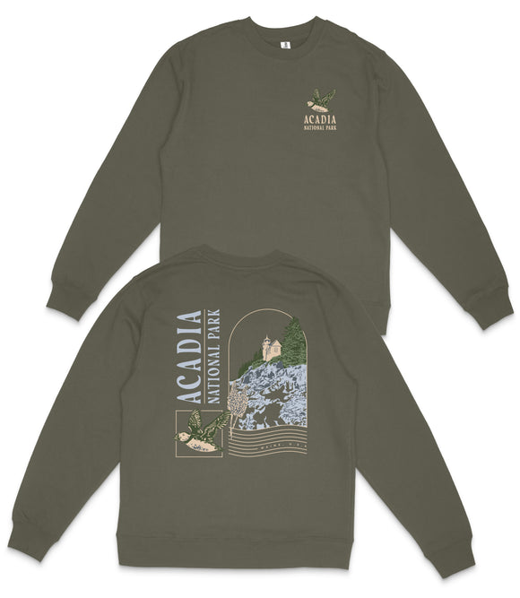 a grey sweatshirt with a graphic design on the back, depicting a scenic landscape with a castle, trees, and mountains.