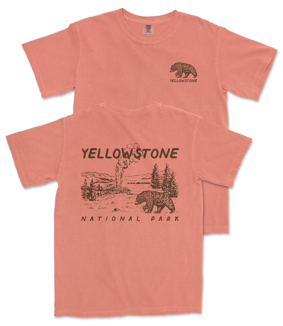 A pink t-shirt with a graphic design depicting a bear and a landscape, along with the text "Yellowstone National Park" printed on it.