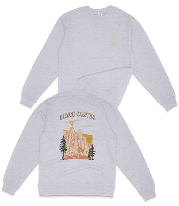 a grey sweatshirt with a graphic design depicting a scenic landscape, including a mountain range and trees.