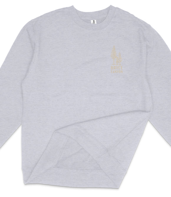 A gray sweatshirt with a gold tree design on the left side.