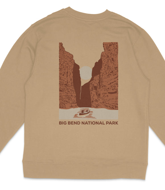 A beige sweatshirt with a graphic design depicting a canyon landscape with a boat in the foreground, and the text "BIG BEND NATIONAL PARK" printed below.