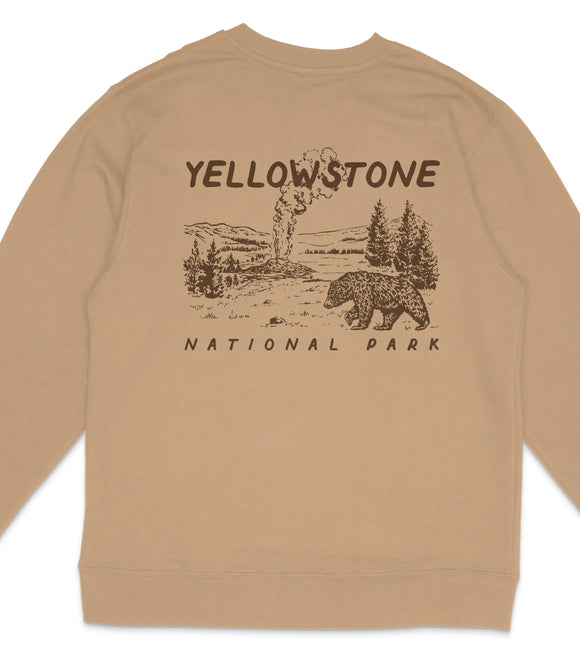 a beige sweater with a graphic design depicting a bear and a landscape with a volcano in the background.