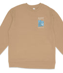 A tan long-sleeved shirt with a graphic design on the front, featuring a blue and white image of a mountain range and the text "BANFF NATIONAL PARK".